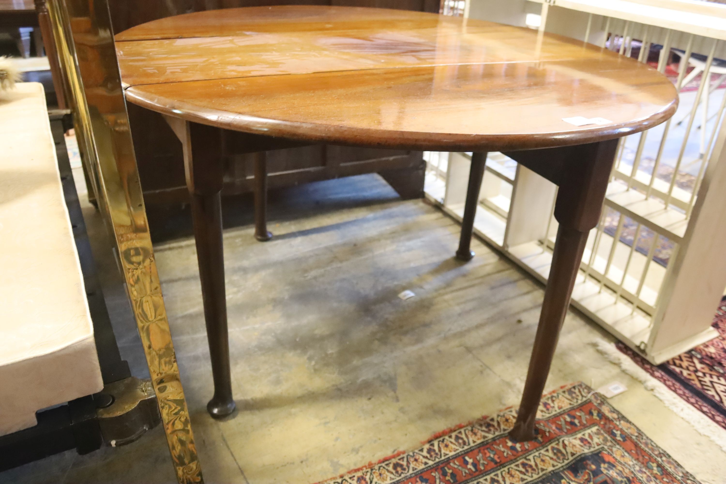 A George III mahogany oval pad foot drop leaf dining table, 116cm extended, 70cm height